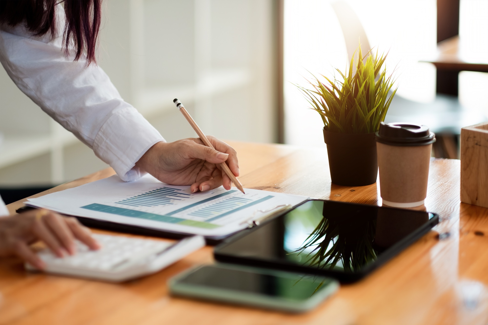 Businesswoman inspecting and checking the business reports graphs to audit the financial reports by