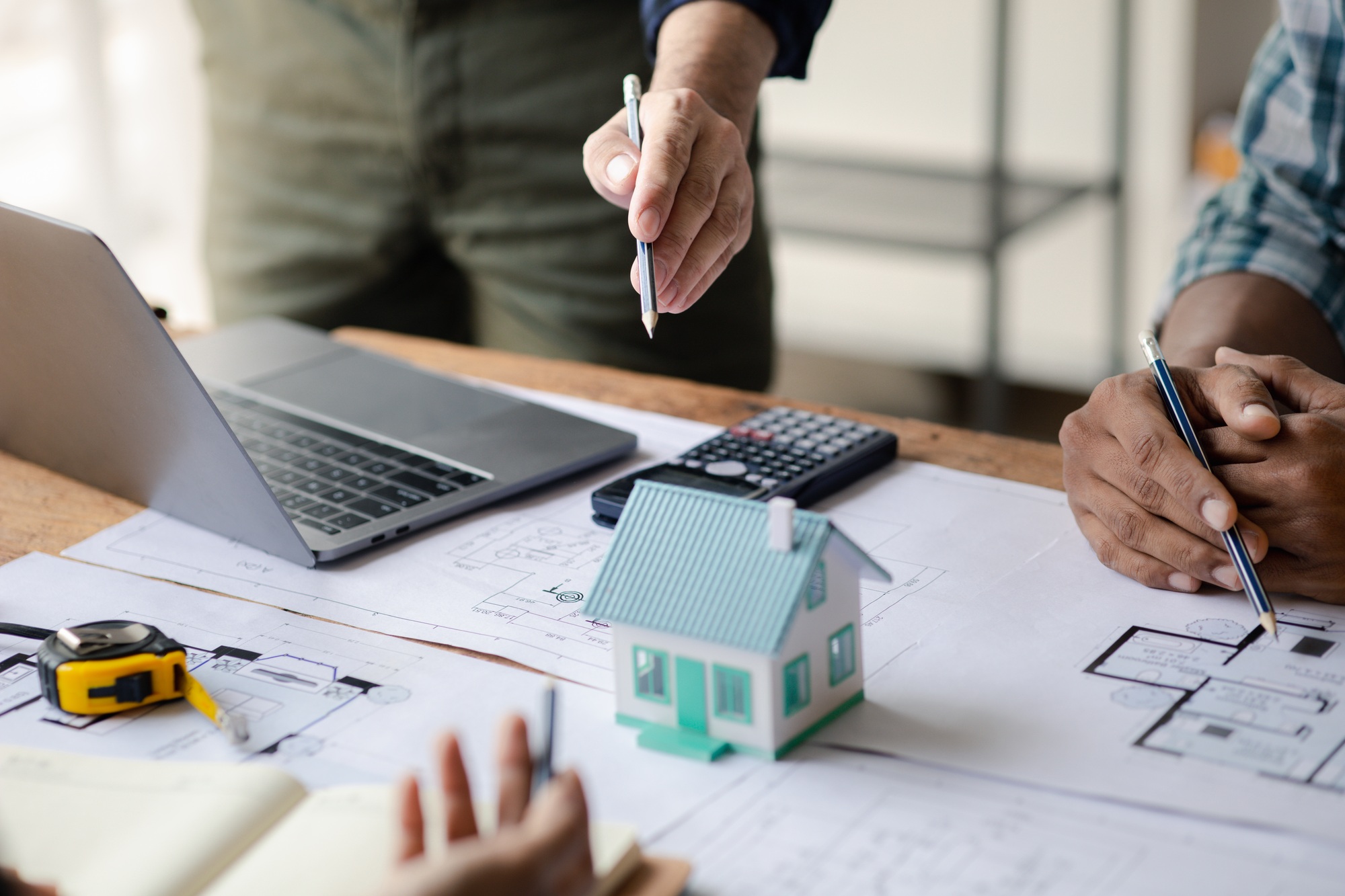Group architects and engineers are in a meeting to discuss and inspect the house designs to meet the